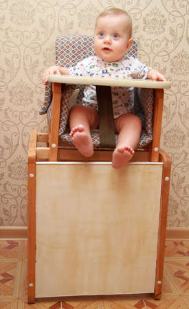 adorable baby on highchair, at homeの写真素材