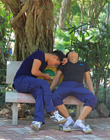 Hanoi, Vietnam - June 1, 2015: two guys are resting on bench in park of Hanoiのeditorial素材