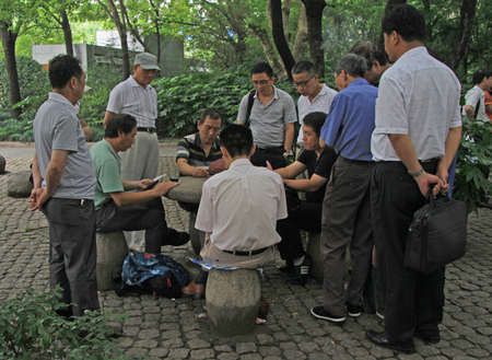 Shanghai, China - July 1, 2015: people are playing cards in park of Shanghaiのeditorial素材