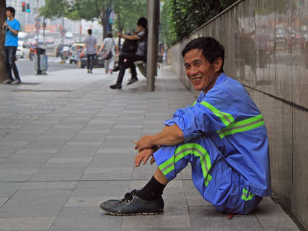 Shanghai, China - July 2, 2015: service man is resting on the street in Shanghaiのeditorial素材