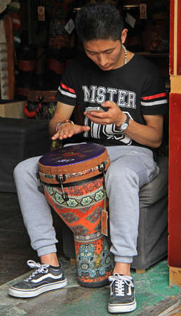Lijiang, China - June 10, 2015: man is playing djembe on the street in Lijiang, China