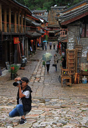 Lijiang, China - June 11, 2015: photographer is preparing to make the shoot on the street in Lijiang, Chinaのeditorial素材