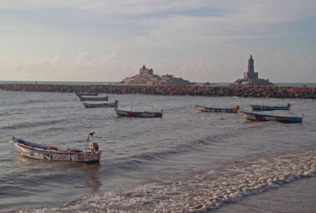 a few colorful boats against background of Swami Vivekananda Rock memorial in Kanyakumari, Indiaの写真素材