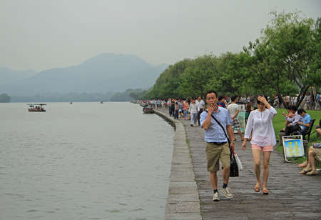 Hangzhou, China - June 28, 2016: people are walking along the embankment of the West lake in Hangzhou, Chinaのeditorial素材