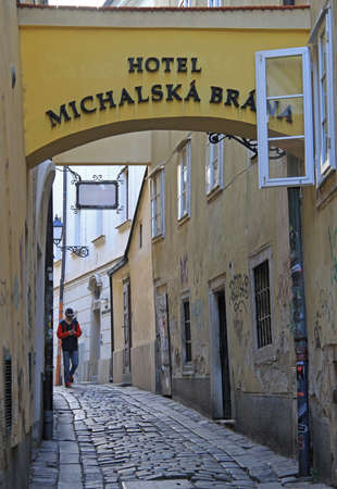 man is walking by the narrow street in Bratislava, Slovakiaのeditorial素材