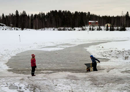 Rovaniemi, Finland - April 10, 2017: children are playing with snow at frozen river in Rovaniemi, Finlandのeditorial素材