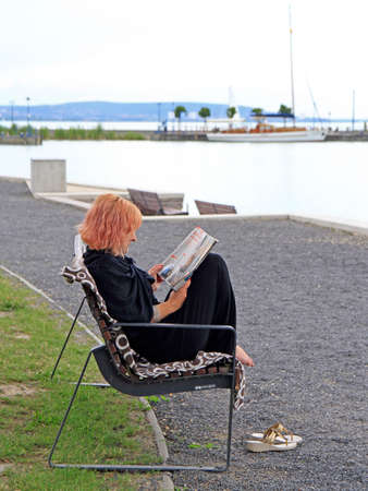 Tihany, Hungary - July 6, 2017: woman is reading a magazine in Tihany, Hungaryのeditorial素材