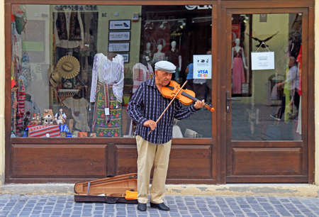 Brasov, Romania - July 25, 2017: street musician is playing violin outdoor in Brasov, Romaniaのeditorial素材