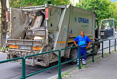 Brasov, Romania - July 25, 2017: worker is standing in front of garbage truckdoor in Brasov, Romaniaのeditorial素材