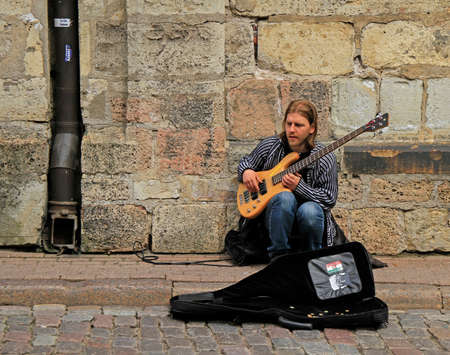 street musician is playing bass guitar outdoor in Rigaのeditorial素材