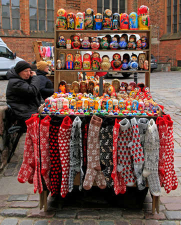 woman is selling souvenirs and warm clothes outdoor in Riga, Latviaのeditorial素材