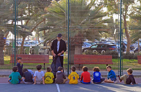 Tel Aviv, Israel - November 30, 2017: man teaches children outdoors in Tel Aviv, Israelのeditorial素材