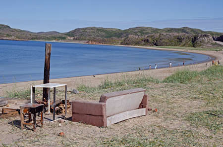 Teriberka, Russia - July 24, 2019: people and the old sofa at beach in Teriberka, Russiaのeditorial素材
