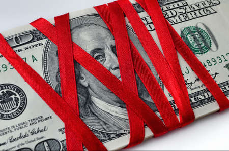 The U S  dollar wrapped by red tapeの写真素材