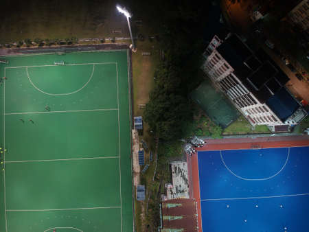 Aerial view of outdoor hockey field during night. The image contains soft focus, grain and noise.