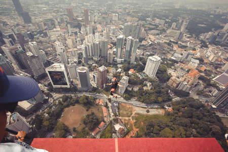 Kuala Lumpur, Malaysia â September 28, 2018: Base Jumpers jump from a 300m high deck during the Kuala Lumpur Tower International Jump.のeditorial素材