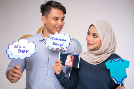 Kuala Lumpur, Malaysia â€“ January, 2020: Handsome man and his beautiful pregnant wife are...