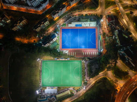 Aerial birdâ€™s eye view of the outdoor hockey field at night. The image contains soft-focus,...