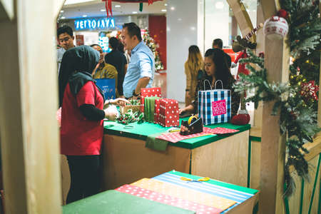 Kuala Lumpur, Malaysia - December 2020: Preparing for Christmas. Young Asian hands pack a giftのeditorial素材
