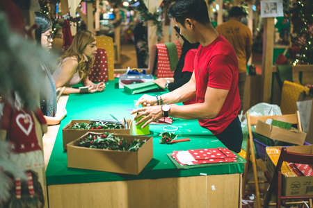 Kuala Lumpur, Malaysia - December 2020: Preparing for Christmas. Young Asian hands pack a giftのeditorial素材