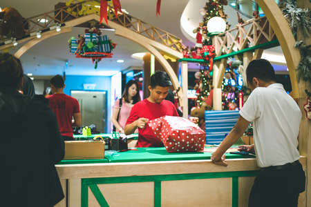 Kuala Lumpur, Malaysia - December 2020: Preparing for Christmas. Young Asian hands pack a giftのeditorial素材