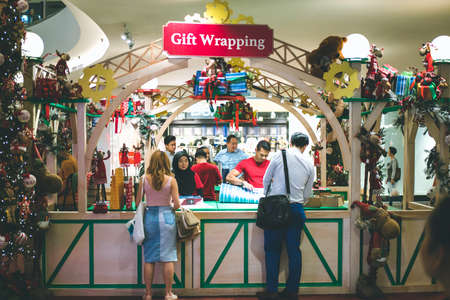 Kuala Lumpur, Malaysia - December 2020: Preparing for Christmas. Young Asian hands pack a giftのeditorial素材