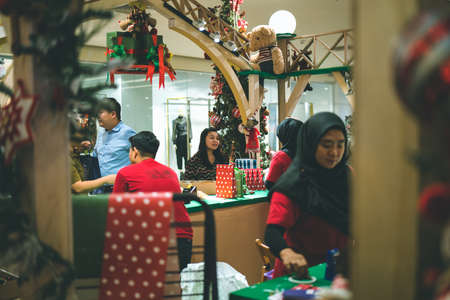 Kuala Lumpur, Malaysia - December 2020: Preparing for Christmas. Young Asian hands pack a giftのeditorial素材