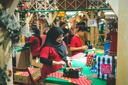 Kuala Lumpur, Malaysia - December 2020: Preparing for Christmas. Young Asian hands pack a giftのeditorial素材