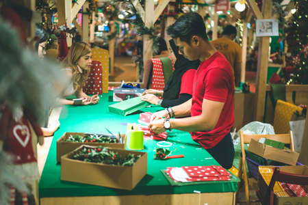 Kuala Lumpur, Malaysia - December 2020: Preparing for Christmas. Young Asian hands pack a giftのeditorial素材