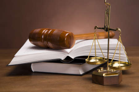 Scales of justice and gavel on desk with dark background