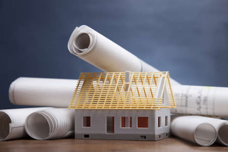 Construction plans and blueprints on wooden tableの写真素材