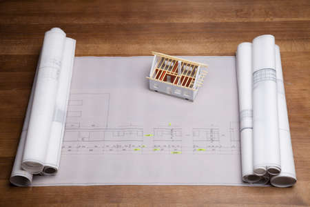 Construction plans and blueprints on wooden tableの写真素材