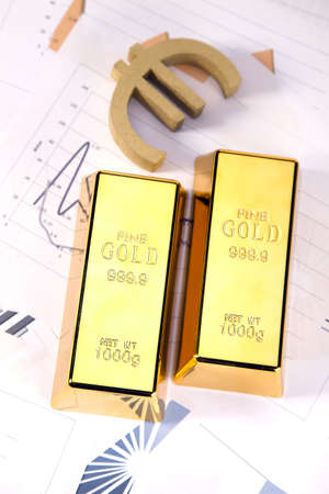 Photo of gold bars on graphs and statistics, studio shots, closeup