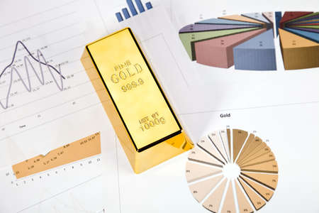 Photo of gold bars on graphs and statistics, studio shots, closeupの写真素材