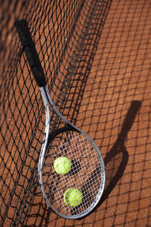Tennis balls and rocket on court field in sunny day