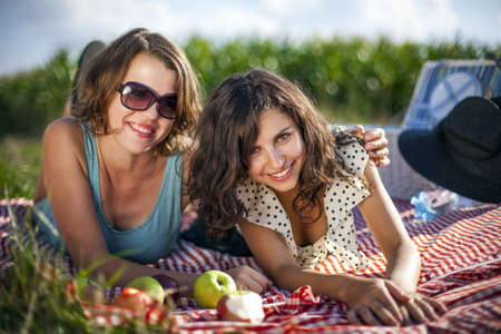 Two pretty girls make a picnic on grassの写真素材