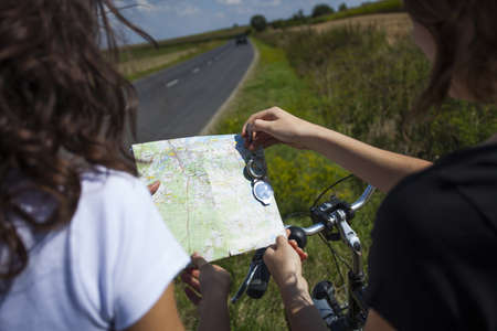 Two pretty girls on bike tour on rock pathの写真素材