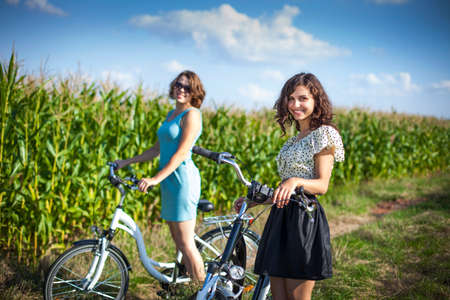 Two pretty girls on bike tour on rock pathの写真素材