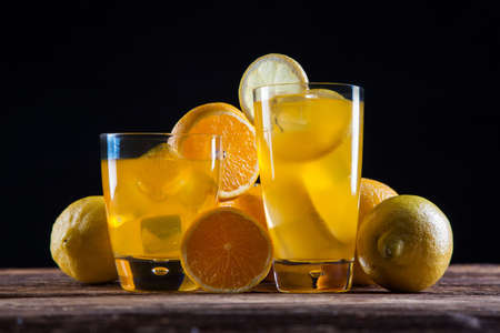 Fresh tasty drinks on black background with fruitsの写真素材
