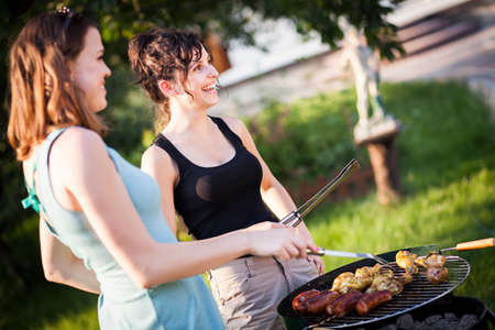 Two pretty girls making food on grillの写真素材
