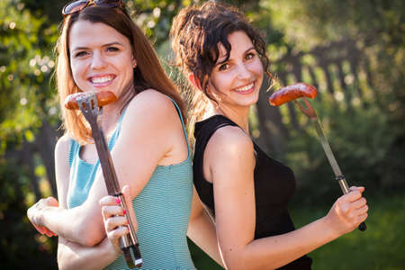 Two pretty girls making food on grillの写真素材