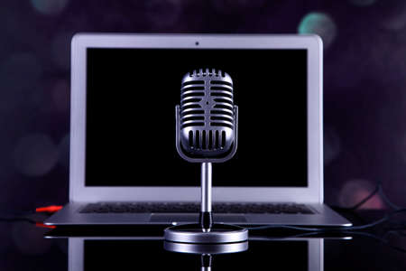 Professional silver microphone on a black glossy backgroundの写真素材