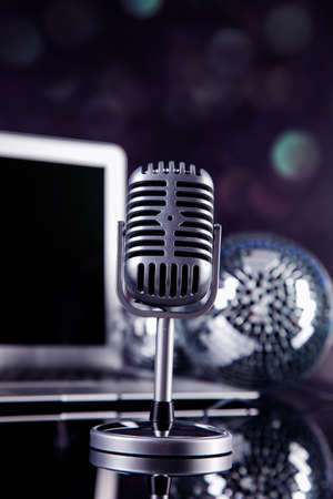 Professional silver microphone on a black glossy backgroundの写真素材
