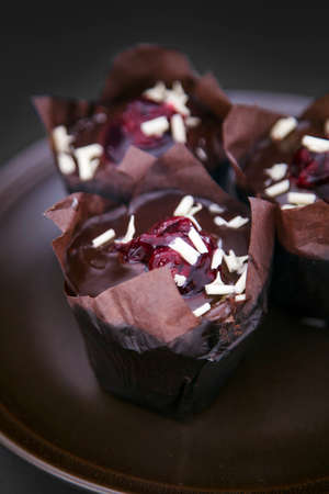 Closeup of delicious muffins on a brown plate.の写真素材