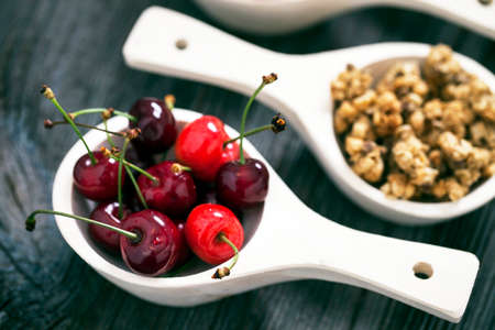 Tasty breakfast. Strawberries, cherries and cereal on wooden tableの写真素材