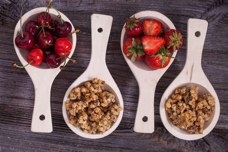 Tasty breakfast. Strawberries, cherries and cereal on wooden tableの写真素材