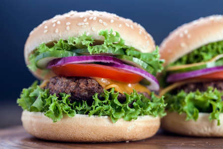 Beef burgers on a wooden board with aromatic spices. Studio Shot