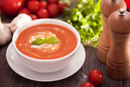 Delicious tomato soup with aromatic spices on a wooden table. Studio shotの写真素材