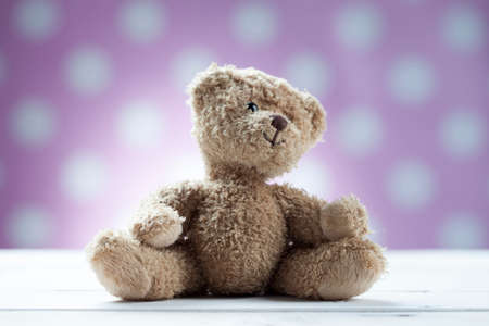 Teddy bear sitting on white wooden deskの写真素材