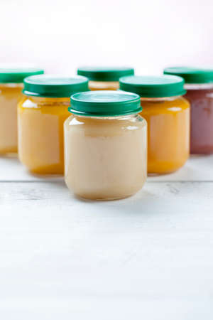 healthy ready-made baby food on a wooden table.の写真素材